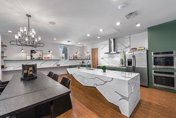 A modern kitchen with a black table and a marble island.