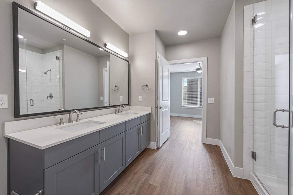 A bathroom with a large mirror and a walk-in shower.