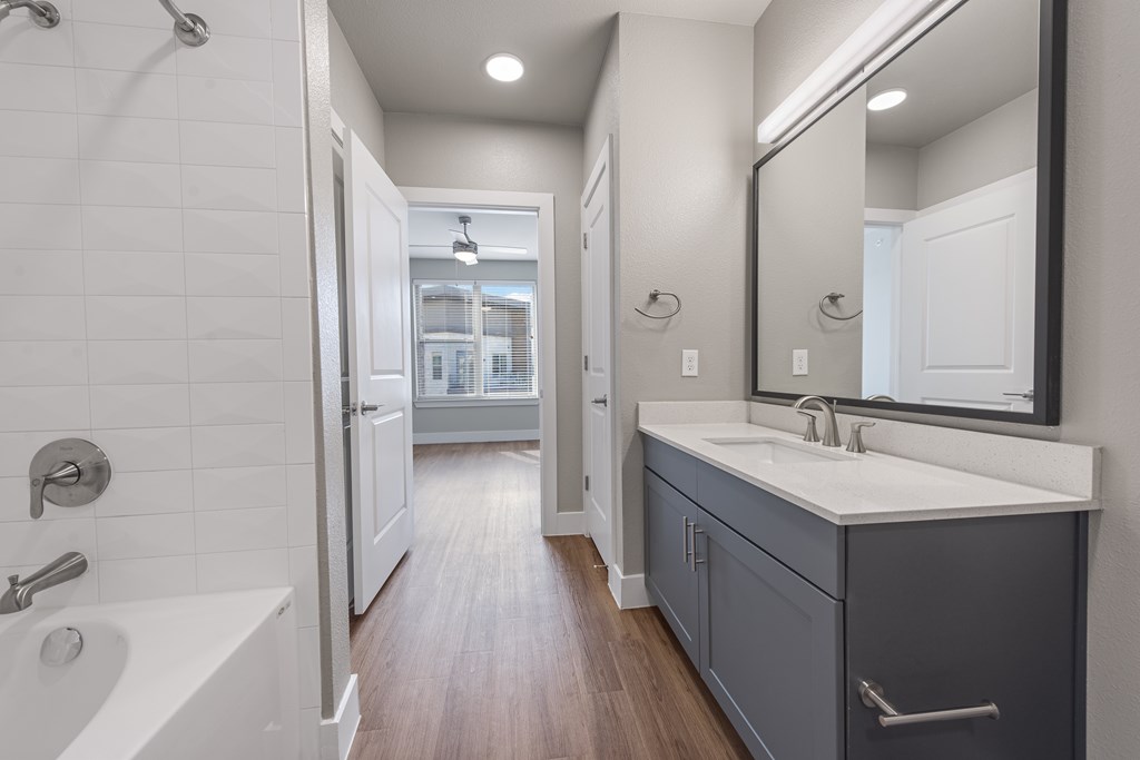 A bathroom with a white sink and a white bathtub.