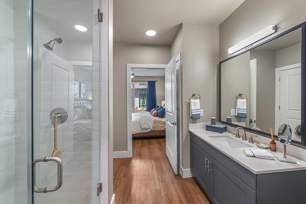 a bathroom with a large mirror and a glass shower  at Presidium Revelstoke, Fort Worth, TX, 76131