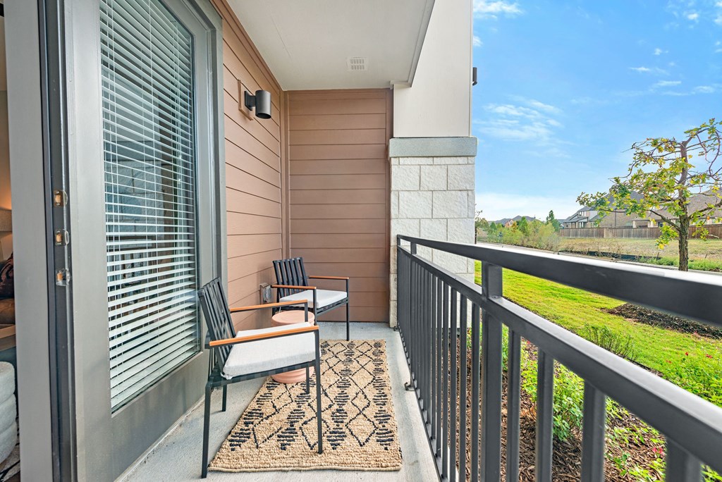 a balcony with two chairs and a rug
