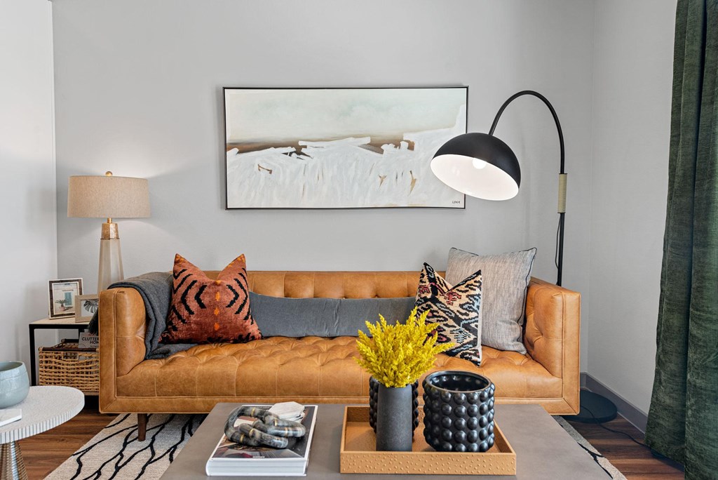 a living room with a brown couch and a lamp