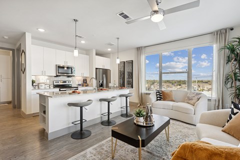 A modern kitchen with white cabinets and a bar area.
