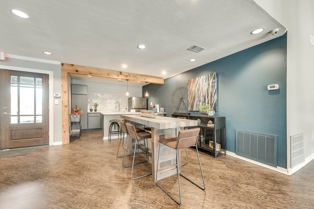 A kitchen with a dining table and chairs.