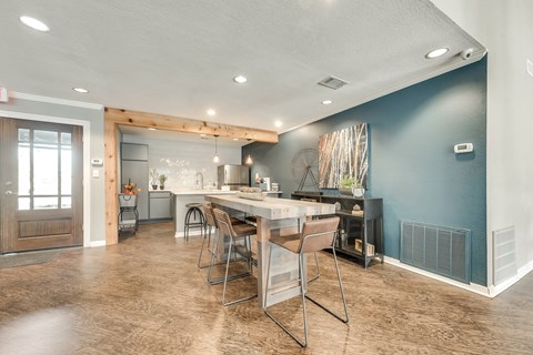 A kitchen with a dining table and chairs.