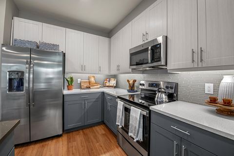 a kitchen with gray cabinets and white countertops