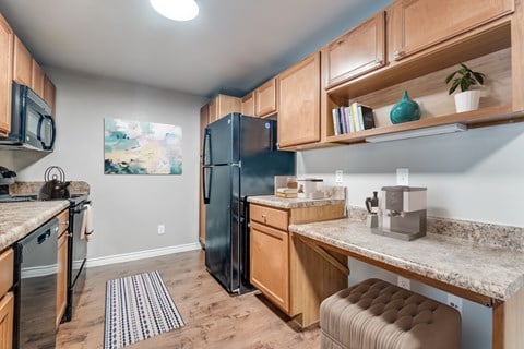 a kitchen with stainless steel appliances and wooden cabinets and a counter top  at Valor at Harlingen, Harlingen, 78552