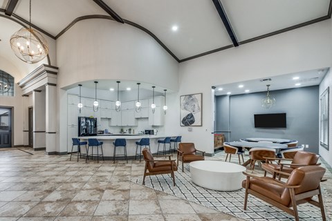 a large lobby with tables and chairs and a tv