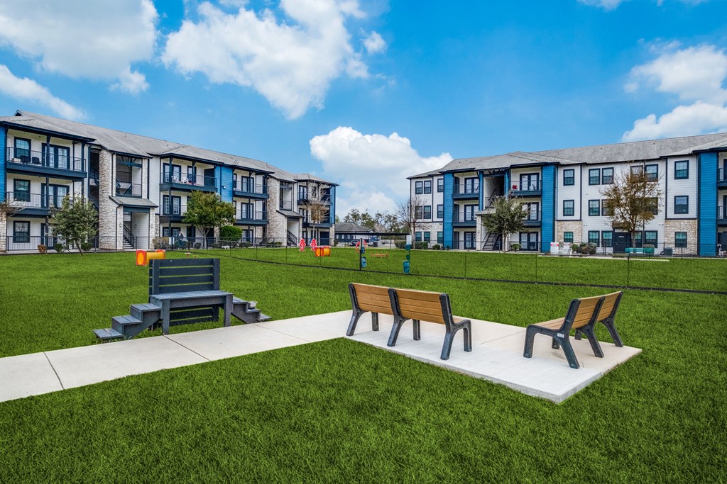a park with benches in front of an apartment building  at Valor at Harlingen, Texas, 78552