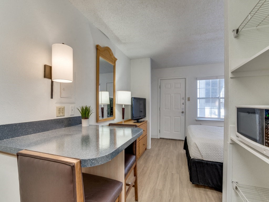 a living room with a kitchen and a bedroom with a bed  at Waterford Studios, Texas, 78758