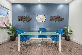 a conference room with blue chairs and a glass table - Photo Gallery 3