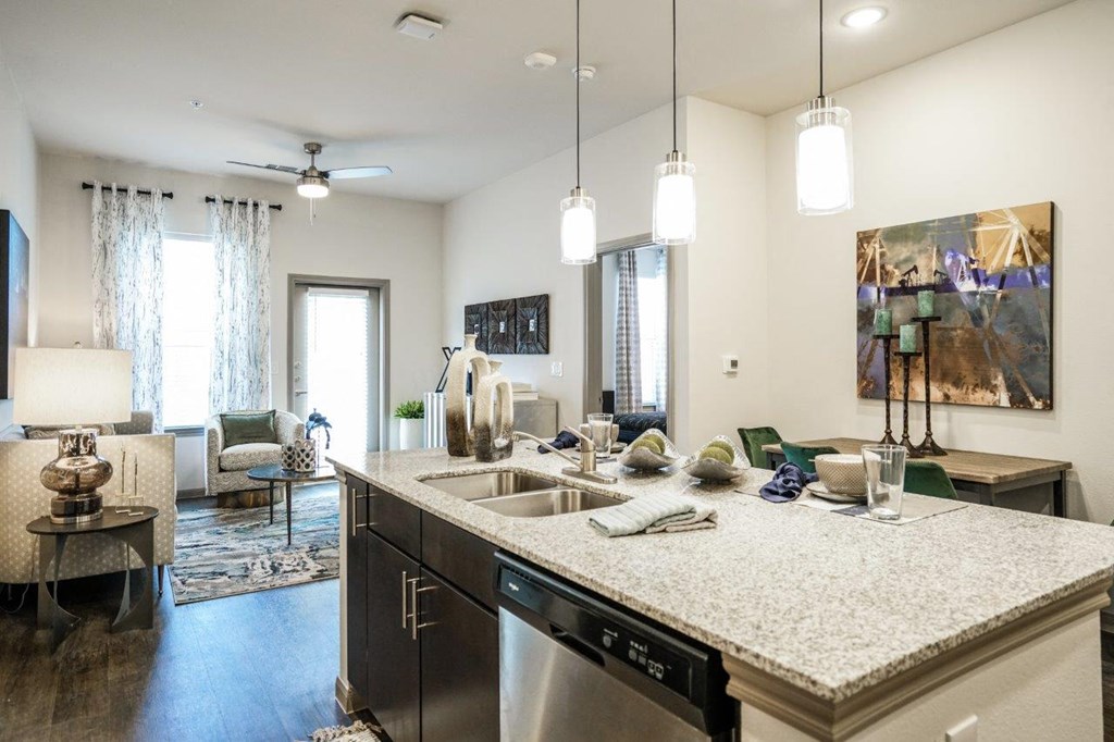 A kitchen with a large island and a dishwasher at The Grand at Manor Apartments, Manor, 78653