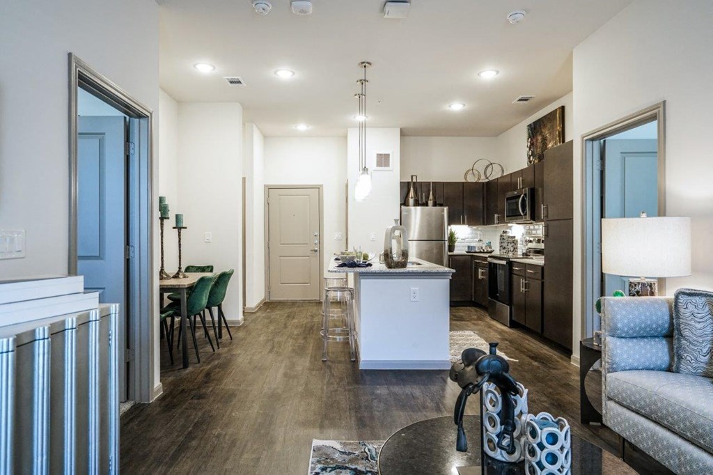 A modern kitchen with a white island and dark wood floors at The Grand at Manor Apartments, Manor