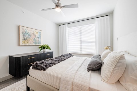 A bedroom with a large bed and a painting on the wall.