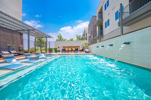 A swimming pool with a waterfall feature in the middle.