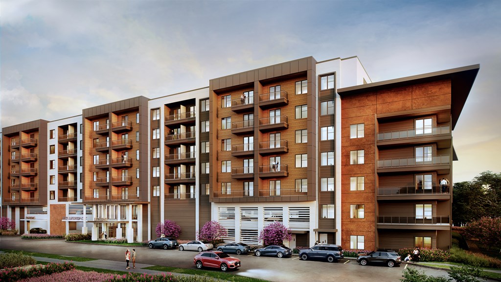 A modern apartment building with a parking lot in front.
