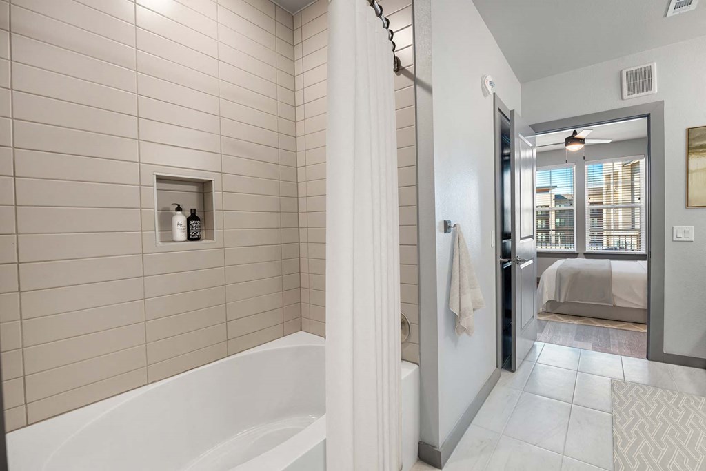 a bathroom with a bath tub next to a shower