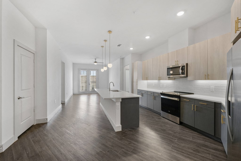 a renovated kitchen with white countertops and stainless steel appliances