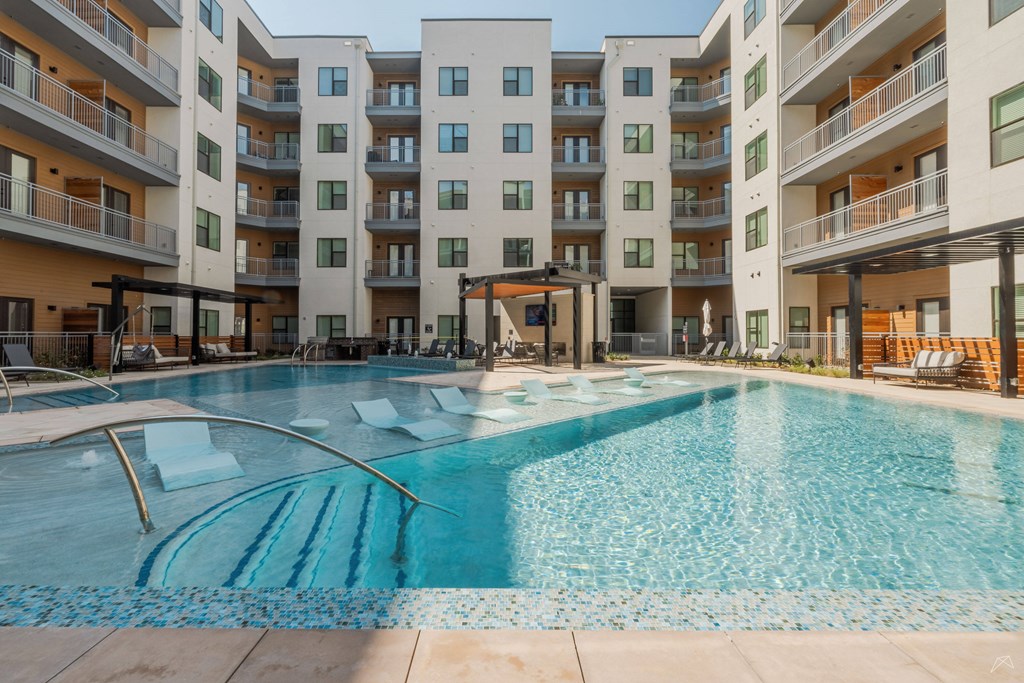 A large swimming pool in front of apartment buildings.