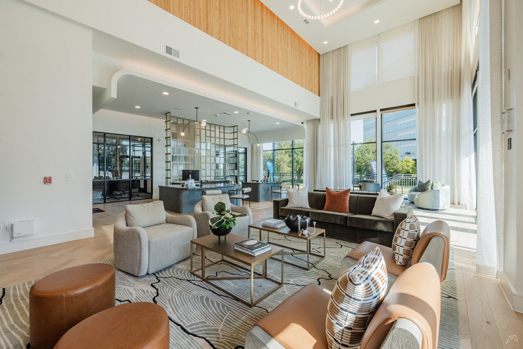 A living room with a large window and a view of trees outside.