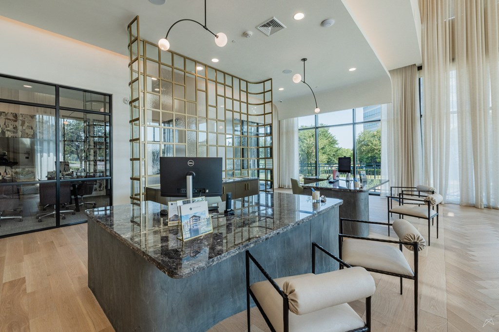 A modern reception area with a marble counter and a glass partition.