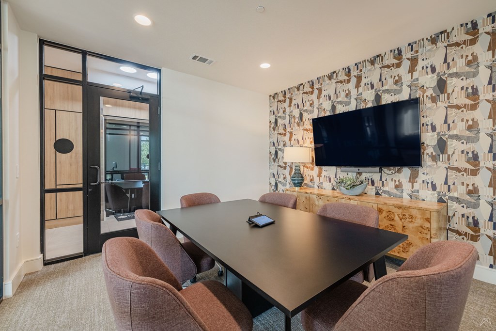 A conference room with a long table and chairs.