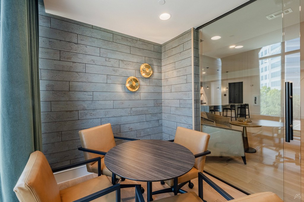 A modern dining room with a round wooden table and chairs.