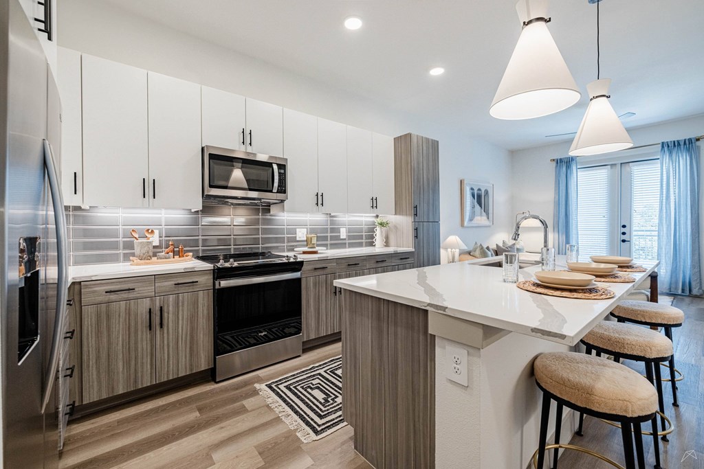 A modern kitchen with a large island and stainless steel appliances.