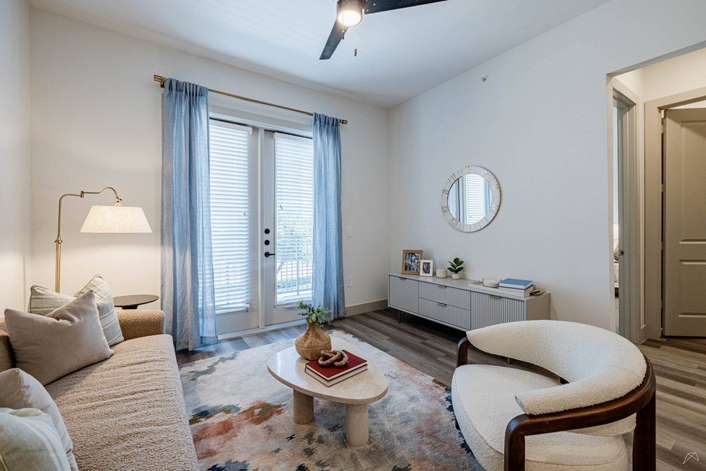 A living room with a couch, chair, and a rug.