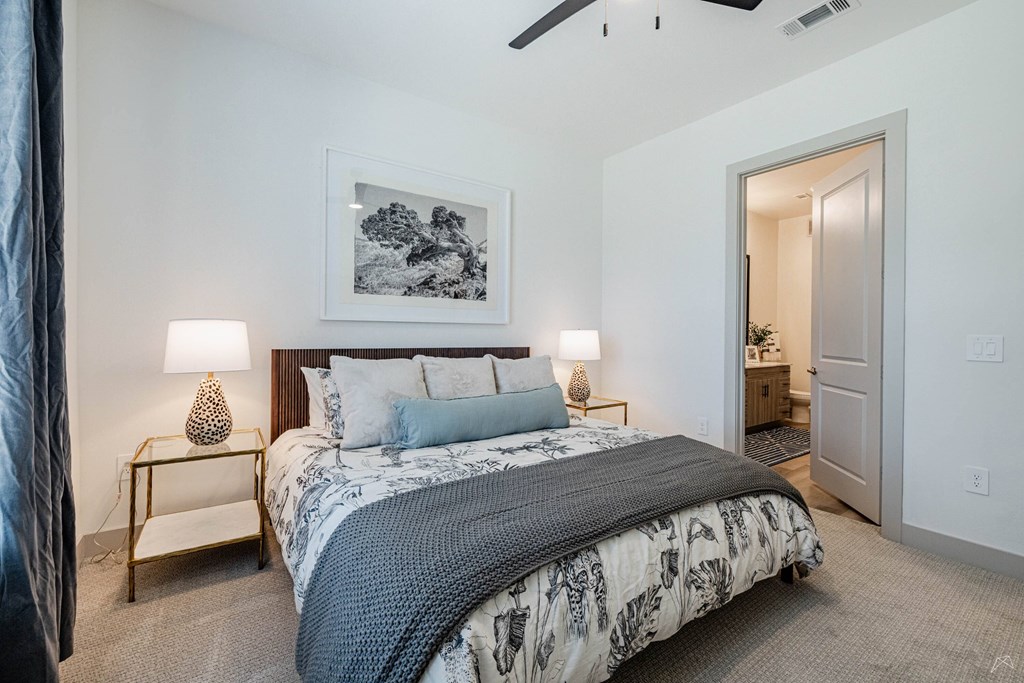 A bedroom with a large bed and a painting on the wall.