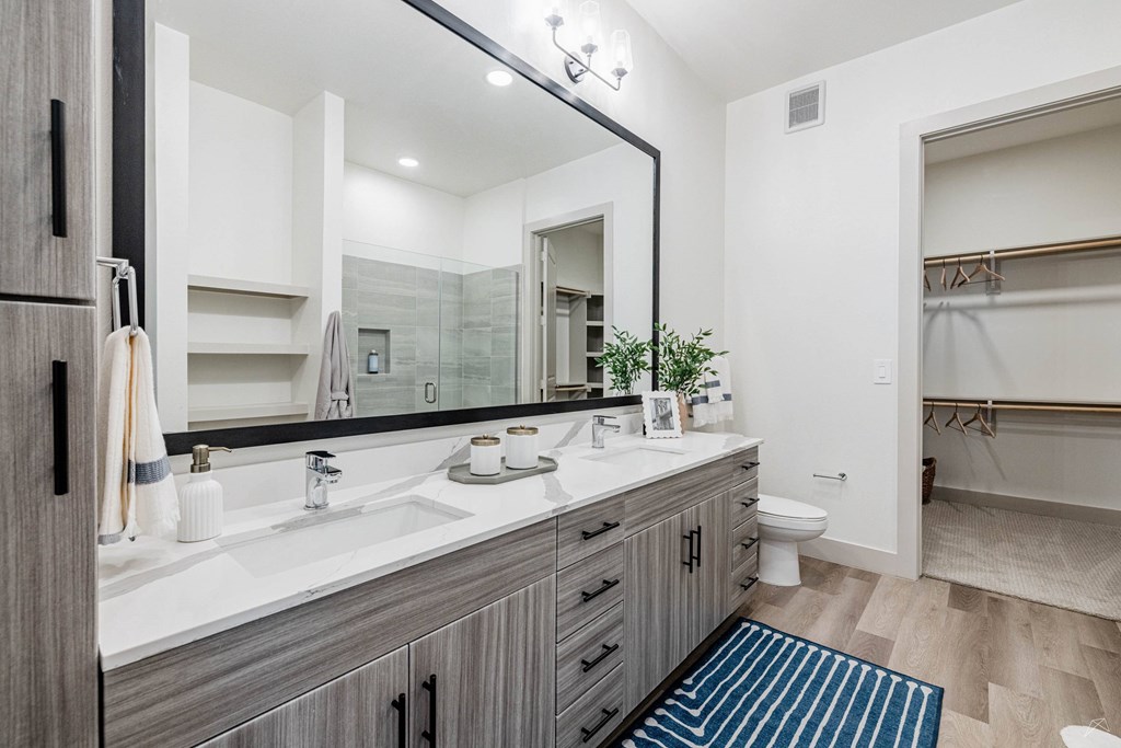 A bathroom with a sink, mirror, and toilet.