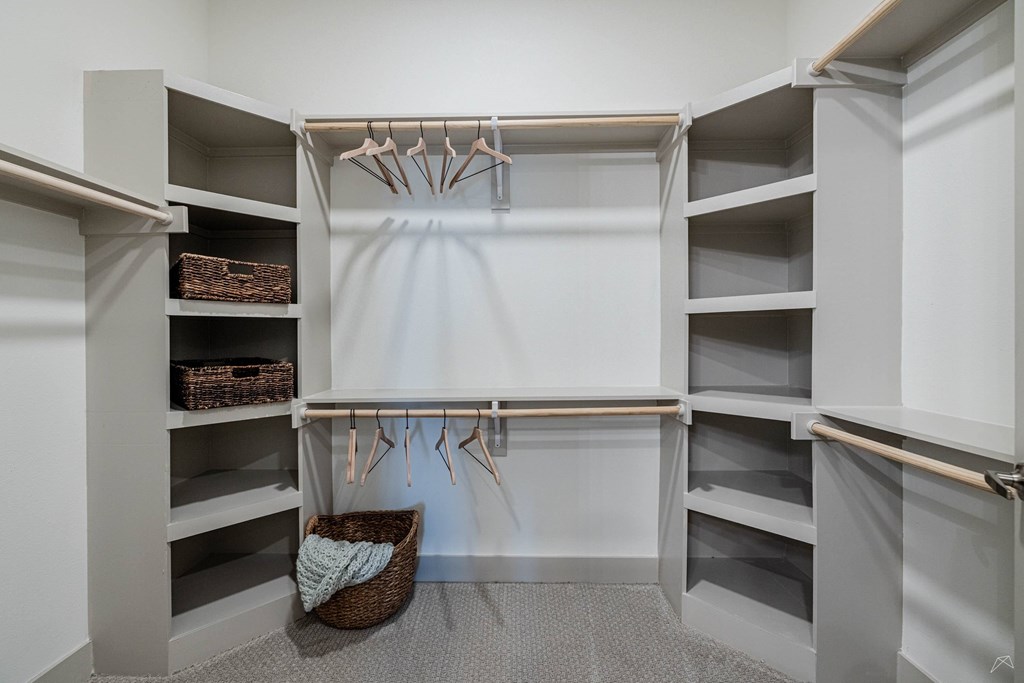 A white closet with a basket and hangers.