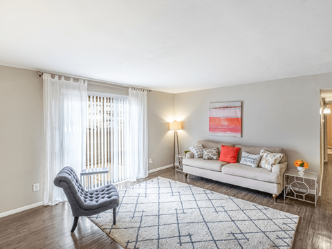 A living room with a grey chair and a white sofa.
