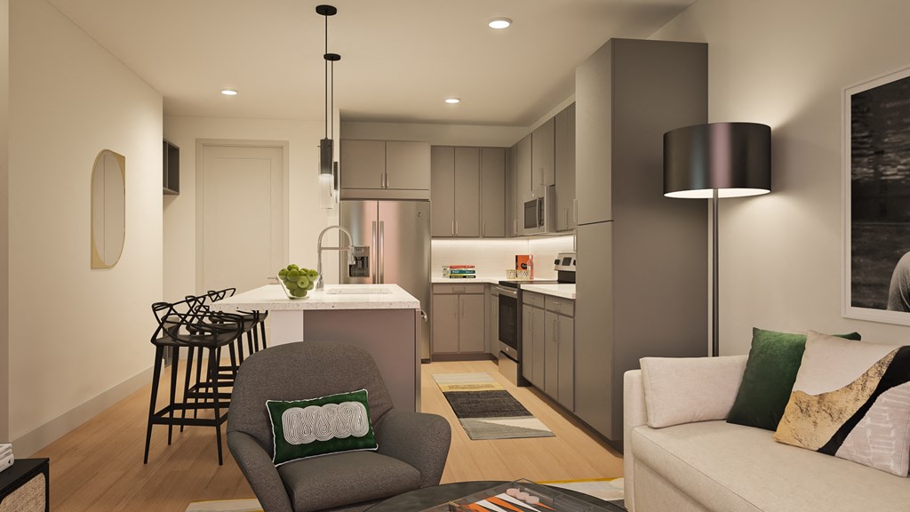 A modern kitchen with a bar stool and a grey armchair.
