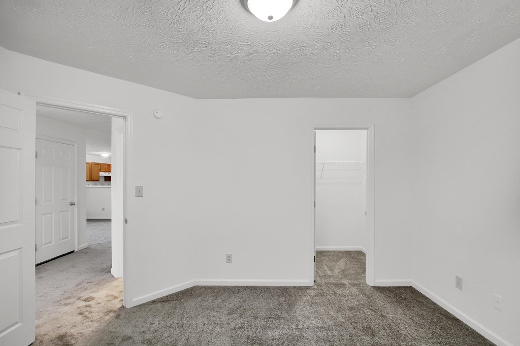 the living room of an empty house with white walls and carpet  at Aberdine Place, Georgetown, KY
