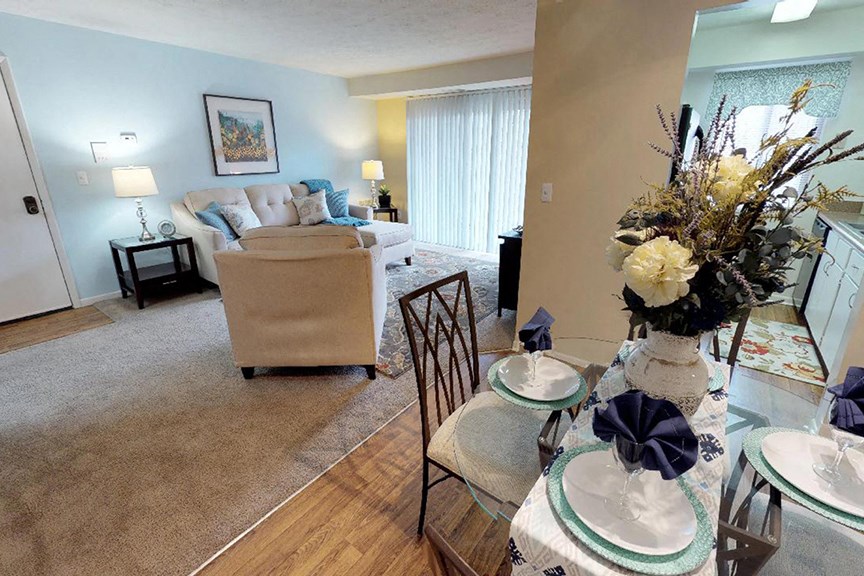 a living room and dining room with a table and chairs  at Hunter's Creek Apartments, Ohio