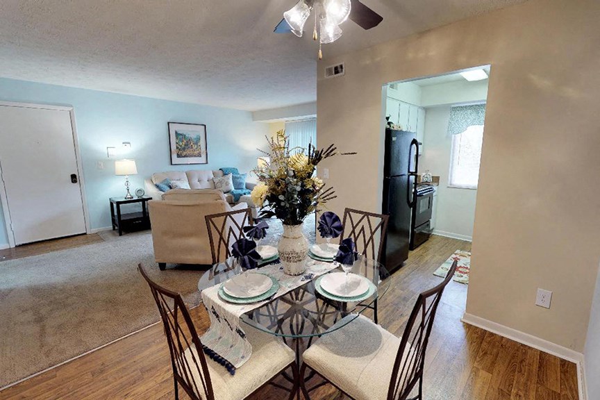 an open living room and dining room with a table and chairs  at Hunter's Creek Apartments, Ohio