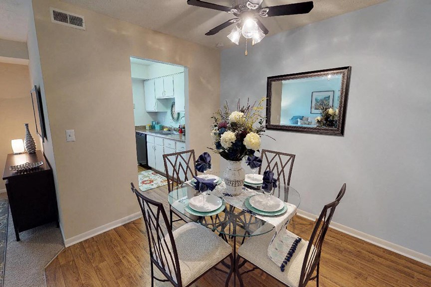 a dining room with a table and chairs and a ceiling fan  at Hunter's Creek Apartments, Cincinnati