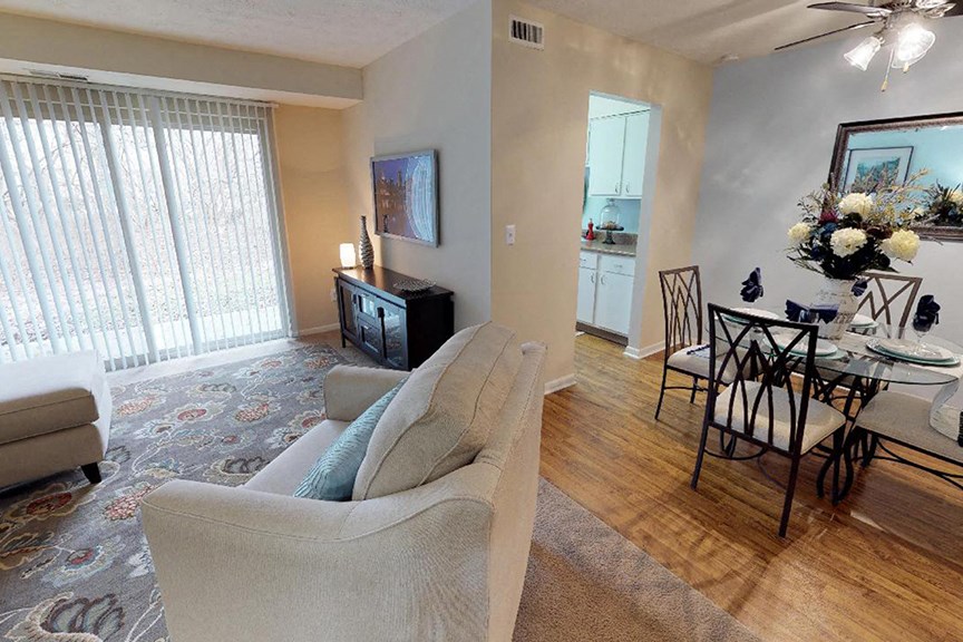 a living room and dining room with a table and chairs  at Hunter's Creek Apartments, Cincinnati, OH
