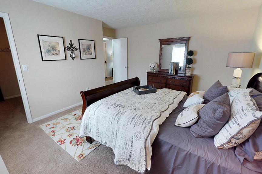 a bedroom with a bed and a dresser in it  at Hunter's Creek Apartments, Cincinnati, OH