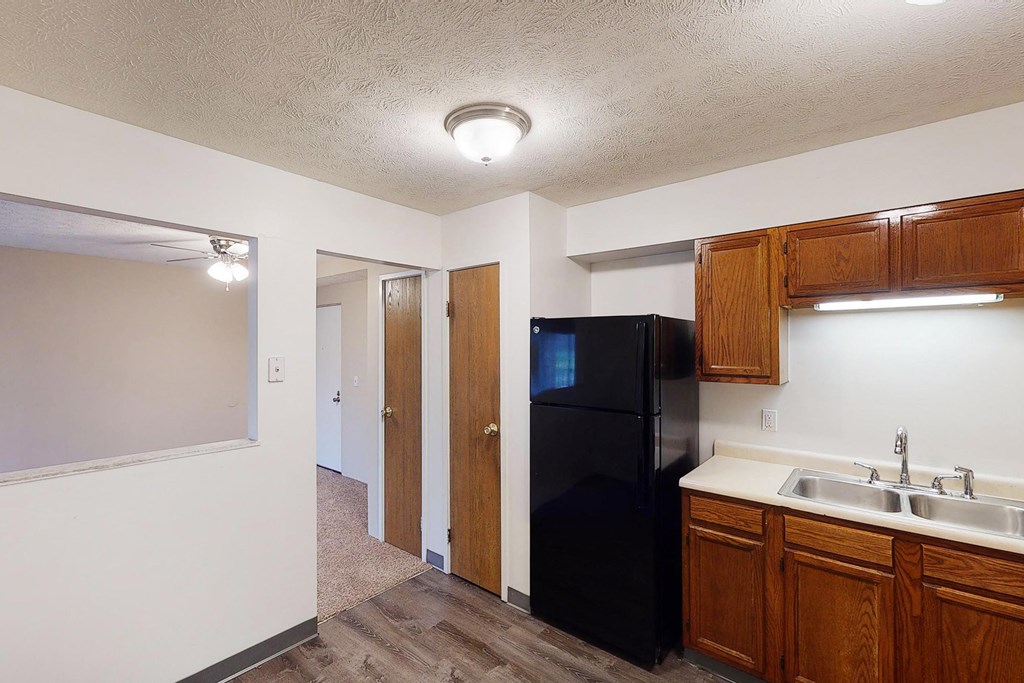 Wooden cabinets and black appliances with ceiling light at Quail Meadow Apartments, Cincinnati, Ohio