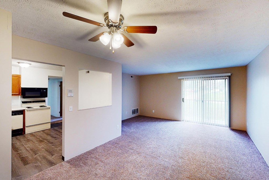 Living room with ceiling light and fan with kitchen nearby at Quail Meadow Apartments, Cincinnati