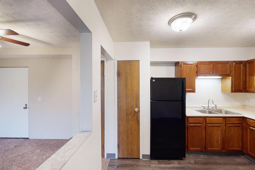 Wooden cabinets and black appliances at Quail Meadow Apartments, Cincinnati, OH