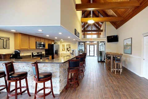 a large kitchen with a bar and chairs