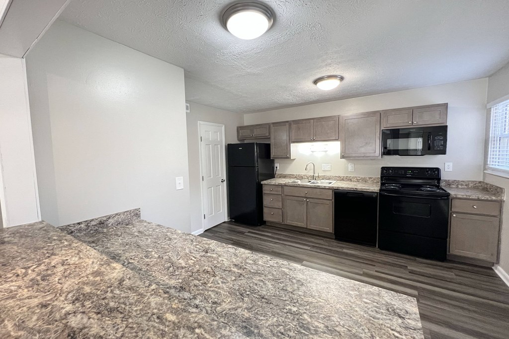 an empty kitchen with black appliances and a granite counter top at Revere Village Apartments, Centerville, 45458
