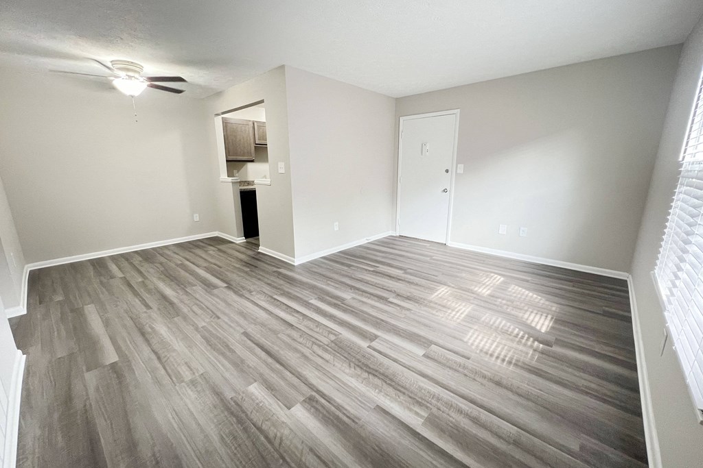 an empty living room with wood flooring in an apartment at Revere Village Apartments, Centerville, OH, 45458