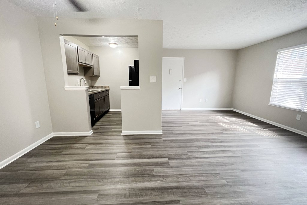 an empty living room with wood floors and a kitchen at Revere Village Apartments, Centerville