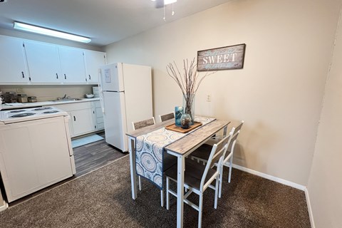 A kitchen with a table and chairs in the middle of the room.