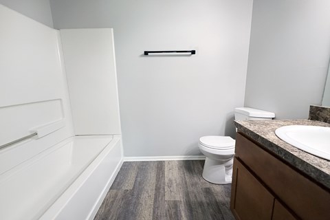 A white toilet sits in a bathroom next to a sink.