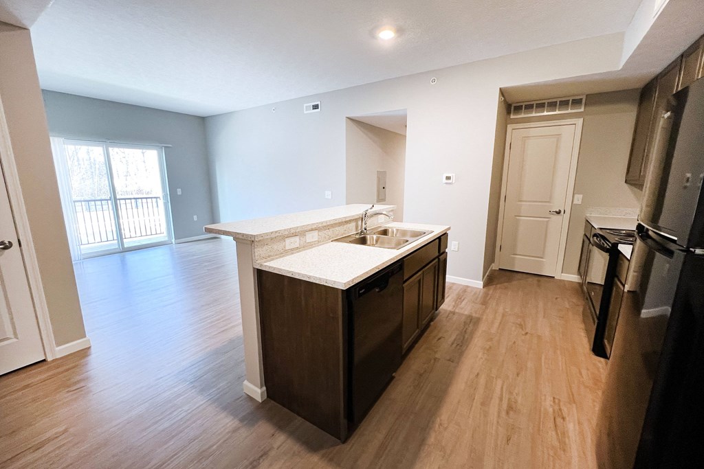 an empty kitchen and living room with wood flooring and a large window  at Brookfield Village Apartments, Ohio